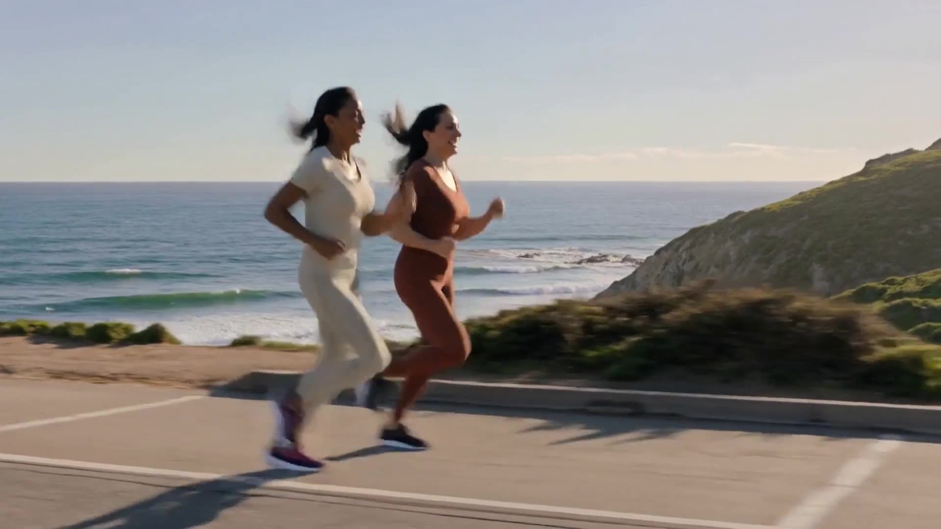 Friends running together beside the ocean